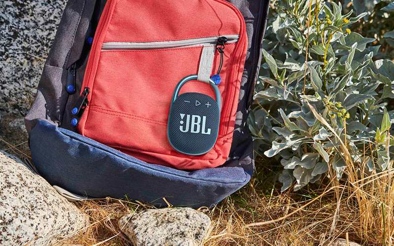 Modrý JBL CLIP 4 připevněný na batohu